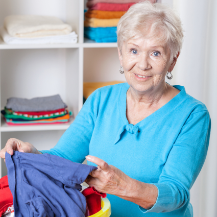 Older adult woman sorting a basket of laundry